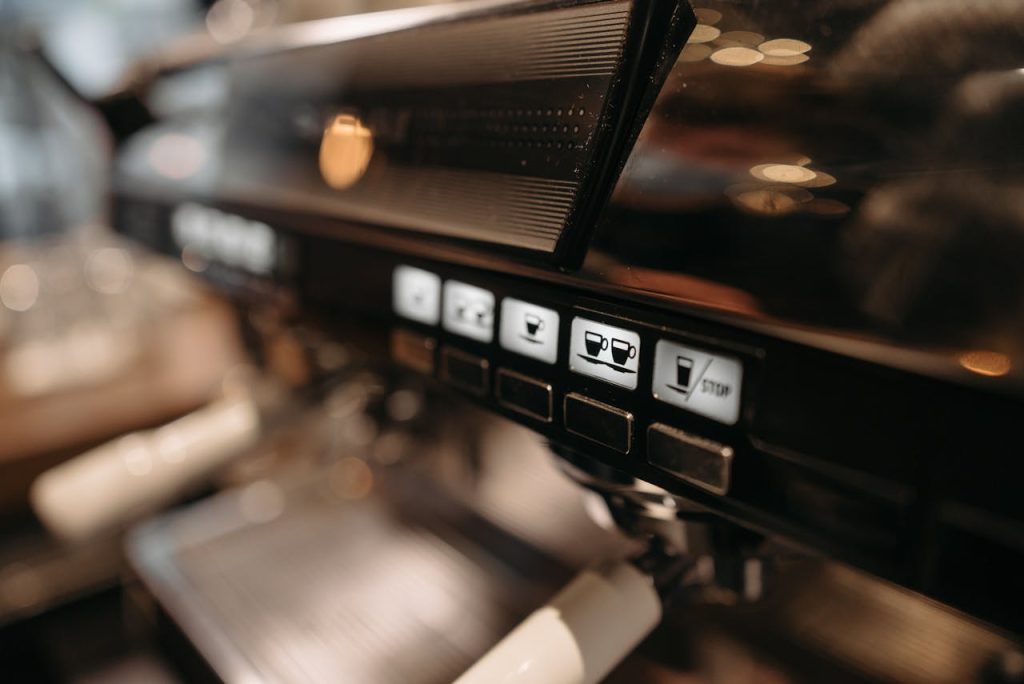 Detailed view of espresso machine panel in a cafe setting, highlighting coffee brewing controls.
